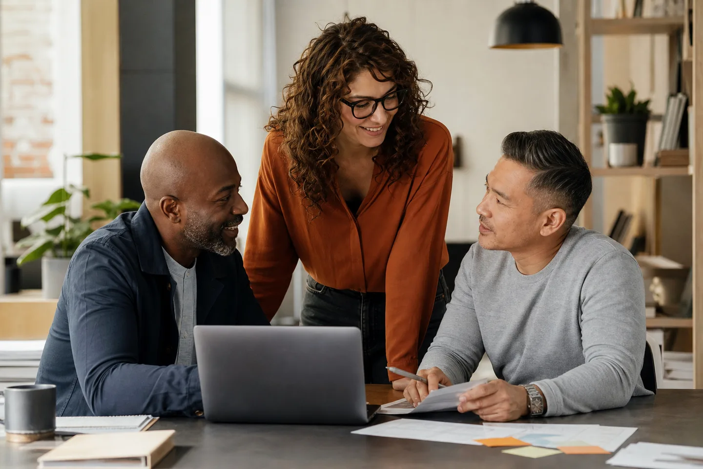 Small-business professionals collaborating around a laptop